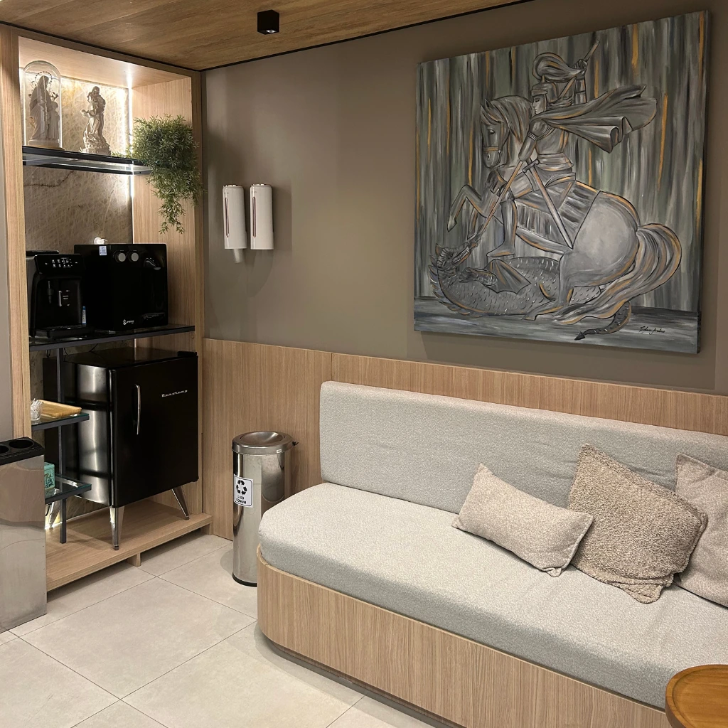 Lounge de espera da MB Prime Saúde Integrada, com sofá e obra de arte
